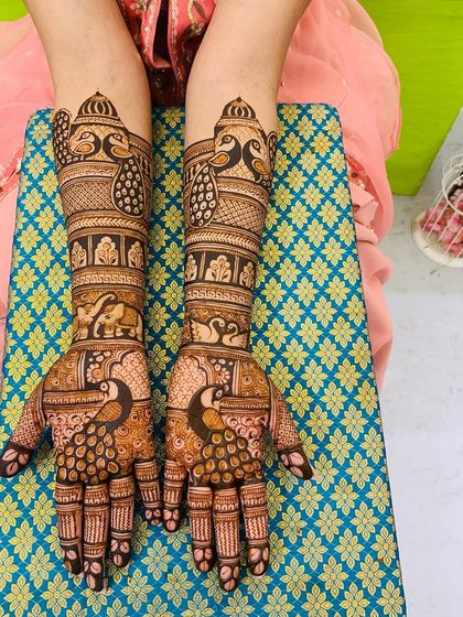 This design is a beautiful mix of traditional motifs. It features peacocks, elephants, and swans, all drawn with fine lines and detailed shading.