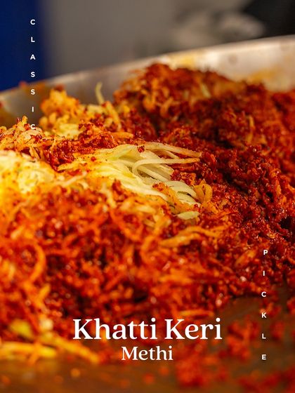 The vibrant red of our spice mix blending with grated mango for our Khatti Keri Methi pickle. This is where the magic begins.