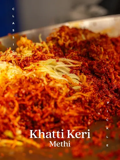 The vibrant red of our spice mix blending with grated mango for our Khatti Keri Methi pickle. This is where the magic begins.