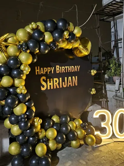 A personalized 30th birthday ring setup in black and gold, with the birthday person's name on the backdrop and light-up numbers.