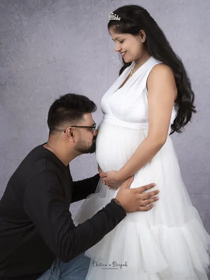 A kiss for the baby. This is one of the most heartwarming and popular poses for couple's maternity shoots, full of love and anticipation.