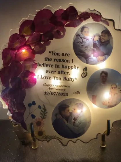 The anniversary frame with its LED lights turned on, creating a warm and magical glow around the photos.