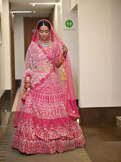 The full view of this stunning bride in her pink lehenga. The makeup was designed to be bright and glowing, perfect for her wedding day celebration.