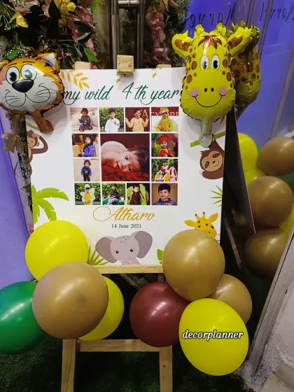 A personalized welcome easel is a wonderful way to greet guests. This one, for a jungle-themed party, features a photo collage of the birthday boy's first four years, surrounded by cute animal-themed foil balloons.
