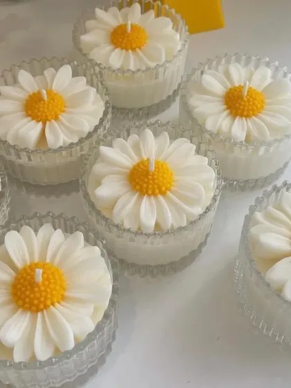 A batch of daisy jar candles in their glass carousel jars.