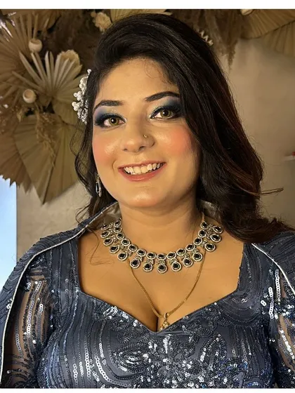 A classic party look with a blue smokey eye to match her navy blue sequin dress.
