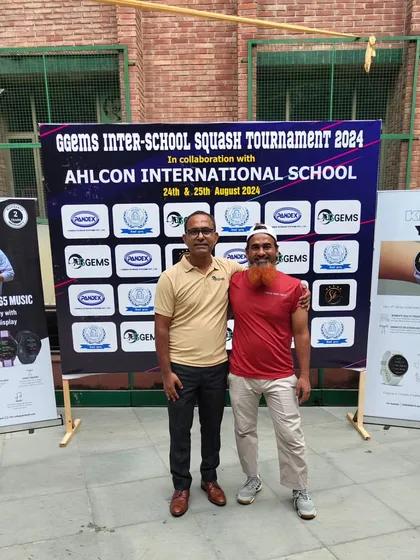 Posing with a guest at our Inter-School tournament, held in front of our sponsor and event banner.