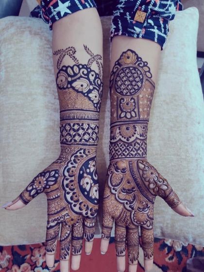 A bold and beautiful design featuring large circular mandalas on the palms, complemented by intricate patterns extending up the arms.