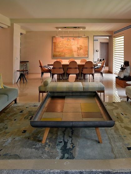 An expansive view of the open-plan living and dining area. The cohesive design, unified by a neutral color palette and flowing layout, showcases how we transform disconnected rooms into a harmonious whole.