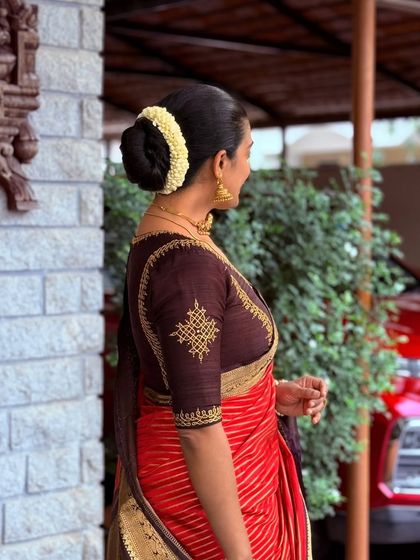 The detailed embroidery on the sleeve of this brown blouse is inspired by traditional motifs, adding a classic touch.