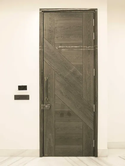 This Sucupira dyed grey veneer door features a dynamic, angular pattern. It's a modern design that still highlights the natural grain of the wood, making it perfect for a contemporary entryway.