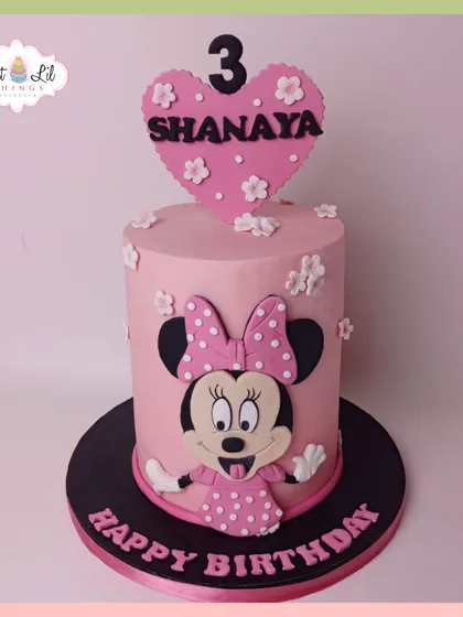 A pretty-in-pink Minnie Mouse cake for a 3rd birthday. This tall cake features Minnie's cheerful face and is topped with a heart-shaped topper.