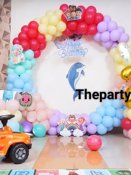 A fun Cocomelon setup with a toy car for the birthday boy. The colorful balloon ring and character cutouts create a playful atmosphere.