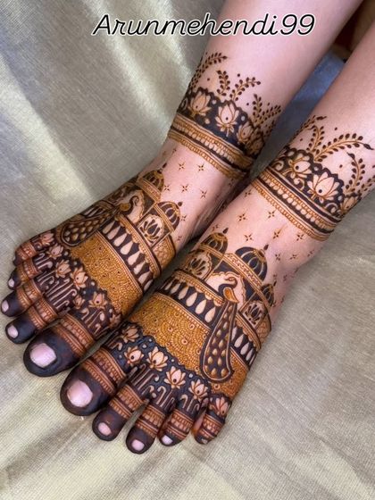 This foot mehendi design features stunning peacocks and palace domes, with a delicate floral band around the ankle.