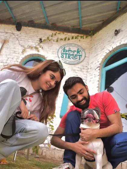 A happy couple posing with their French Bulldog. Our cafe is a great spot for a date, especially when your furry third wheel can join.