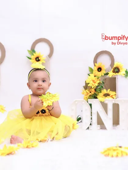 A beautiful portrait from a sunflower themed first birthday shoot. The bright yellow tulle dress and floral props create a picture of pure sunshine.