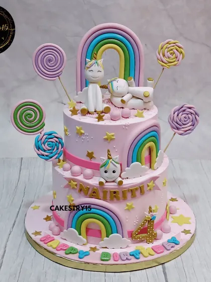 A vibrant two-tier Candyland unicorn cake. This choco-vanilla cake is a burst of color, decorated with fondant unicorns, rainbows, and an assortment of candy lollipops for a fun and sweet celebration.