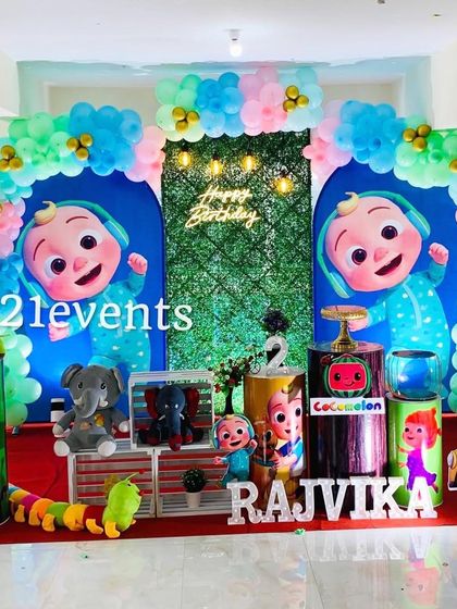 This Cocomelon setup features a grass wall with a neon sign, creating a nice contrast with the colorful characters and balloons.