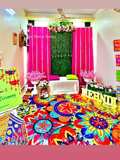 A wide view of the entire Mehendi/Dholki setup, showing how I can transform a room into a vibrant celebration space with a colorful carpet, backdrop, and props.