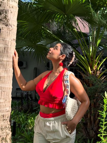 Looking up at the palm tree. This pose is aspirational and captures the feeling of being in a tropical paradise.
