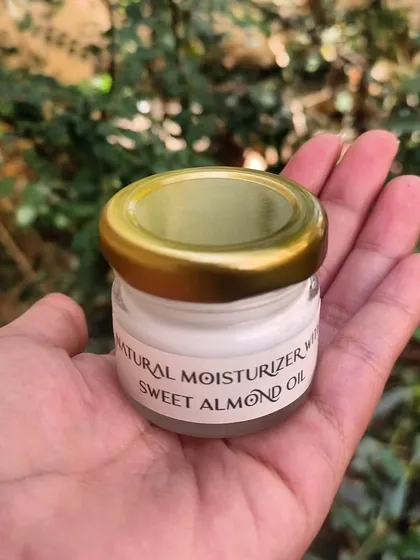 A close-up of the mini sweet almond oil moisturizer from a custom gift set. These little jars are perfect for travel or for trying out a new blend.