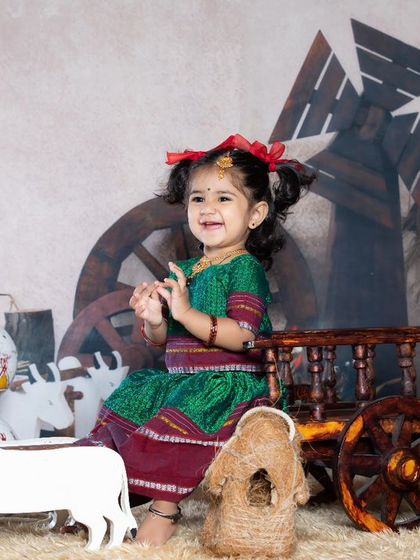 A sweet little girl in a traditional langa voni, enjoying the village fair setup.