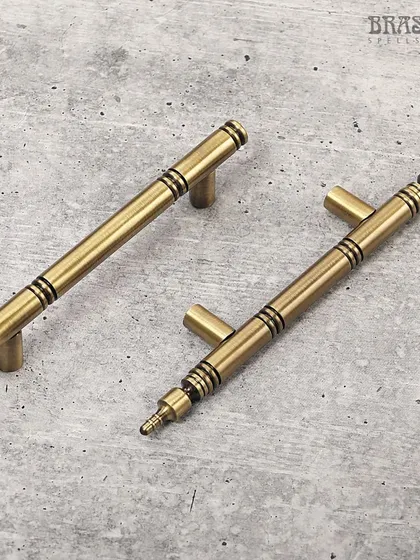 The Vivaldi cabinet handle in an Antique Brass finish. Its clean, cylindrical form is accented with subtle dark rings, adding a touch of visual interest to a minimalist design. Perfect for refreshing any modern kitchen or bathroom.