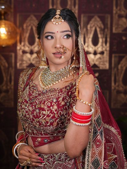 A close-up portrait of a bride in our maroon lehenga, highlighting the detailed blouse and dupatta work.