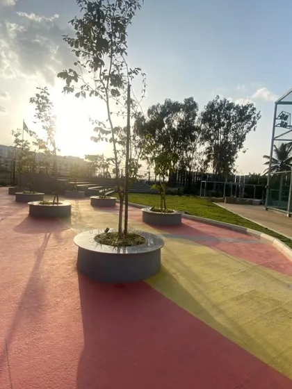 A view of the finished multi-colored plaza at Vaishnavi Tech Square, with newly planted trees in circular planters.