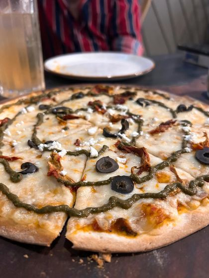 A delicious pizza from the new 145 Cafe & Bar in Cyberhub. This close up shot makes the toppings and cheesy goodness the star of the show.