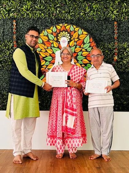 We welcome practitioners of all ages. Here, an instructor presents certificates to a couple who completed our retreat, proving that the journey of wellness has no age limit.