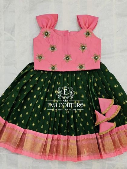 A simple and sweet Pattu Pavadai in green and pink. The sleeveless blouse has delicate embroidery, and the skirt has a traditional gold border.