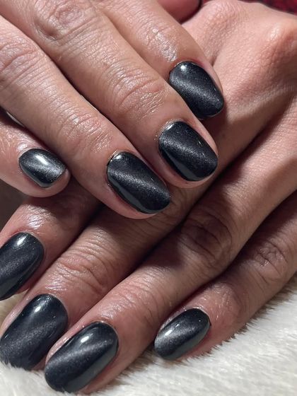 A classic black cat-eye manicure. The magnetic polish creates a silvery stripe that moves in the light, giving the nails a mysterious and sophisticated look.