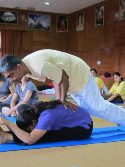 A throwback to a TTC from 2011, where a teacher assists a student in Paschimottanasana, the seated forward bend. Our lineage of teaching has a long and rich history.