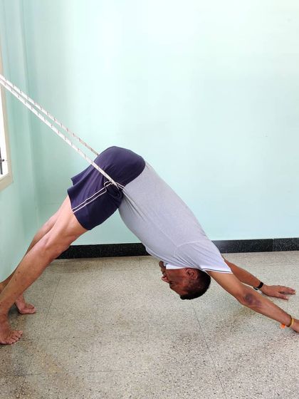 Another view of Adho Mukha Shvanasana with rope assistance. Notice how the rope helps to shift the weight back towards the heels, deepening the stretch in the hamstrings and calves.