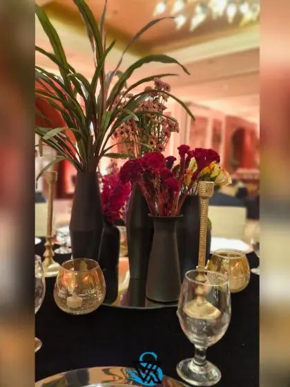 A table setting detail from the burnt orange themed event. We used black vases and gold candle holders to complement the dark tablecloths and warm floral arrangements.