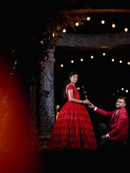A creative shot using foreground blur to create a dreamy and artistic frame for the couple at the stone gazebo.