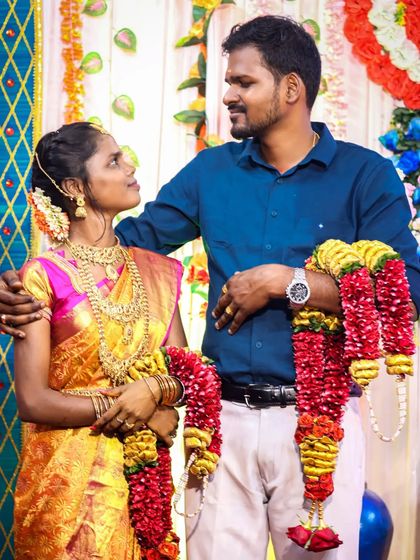 A candid interaction between the couple during their reception. The way they look at each other while holding their garlands shows their natural chemistry and affection.