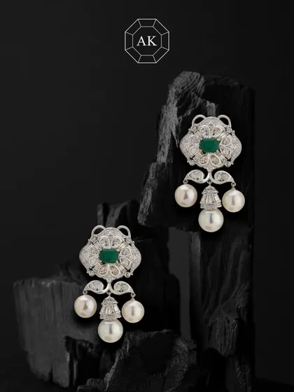 Soft sparkle, strong statement. These earrings bring together rich emeralds, various diamond cuts, and South Sea pearls in 18K gold.