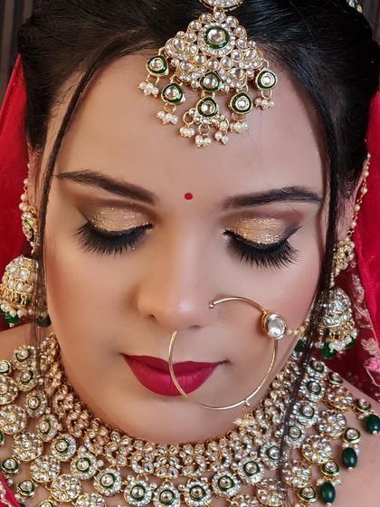 A close-up of this red bride's stunning golden eye makeup. The glitter adds a touch of glamour to her traditional look.