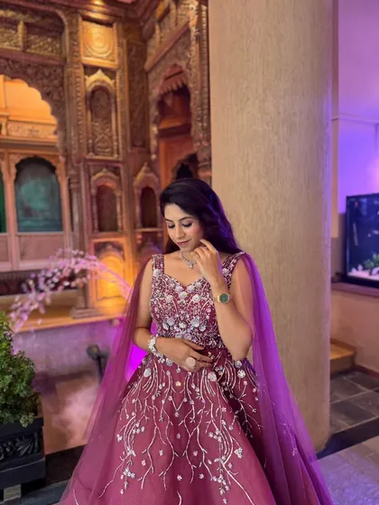 A quiet moment in a stunning gown. The intricate silver embroidery on this wine-colored dress makes it a sophisticated choice for any formal event.
