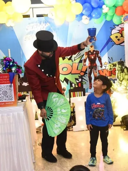 A young superhero fan helps me with a trick in front of the Avengers-themed backdrop. The decorations serve as the perfect setting for a magical and heroic birthday adventure.