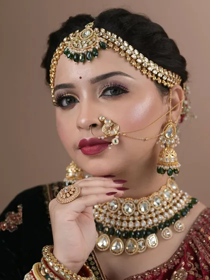 This is the final result of a student's hard work: a complete bridal look with intricate jewelry, bold makeup, and a confident posture.