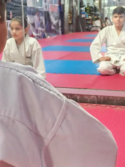 A young student practices maintaining eye contact and a calm posture during a meditation exercise, building focus and self-control.
