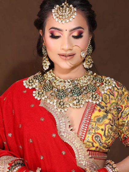 A close-up of the heavy Kundan and green bead necklace, showing the intricate work and quality of the stones. This piece is available for rent.