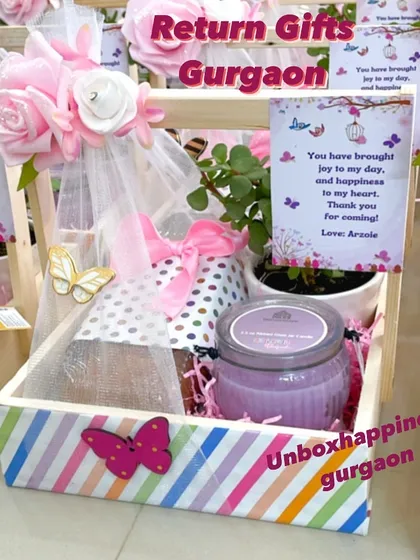 A close-up of the butterfly-themed return gift, highlighting the personalized card and the pretty pink floral decorations.