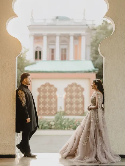 Framed by a beautiful archway, Ayush and Sakshi share a look during their pre-wedding shoot. This composition uses architectural elements to create a sense of depth and story, focusing on the connection between them.