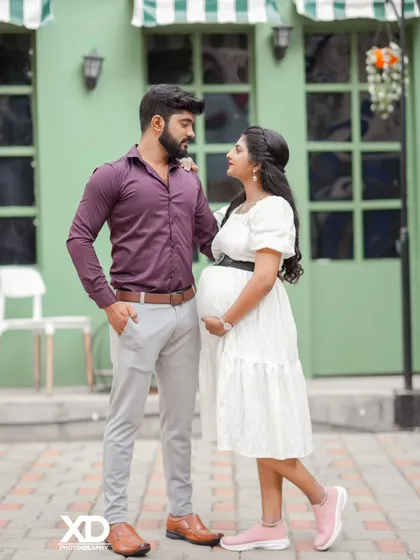 A candid shot of a couple sharing a look, captured in a modern, stylish outdoor setting.