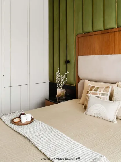 This angle shows the seamless integration of the wardrobe into the bedroom design. The clean white finish complements the green accent wall and soft bedding, creating a cohesive look.