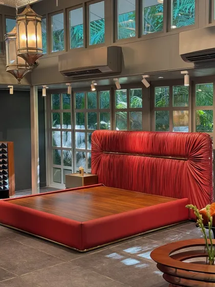 A glimpse of our exhibition at The Folly, Amethyst. This shot features our dramatic red bed with a ruched headboard, a signature piece that combines bold color with intricate texture.